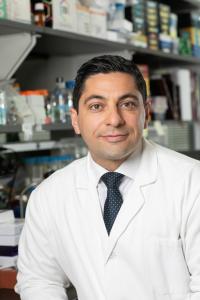 Image of Ben Izar in a white lab coat.